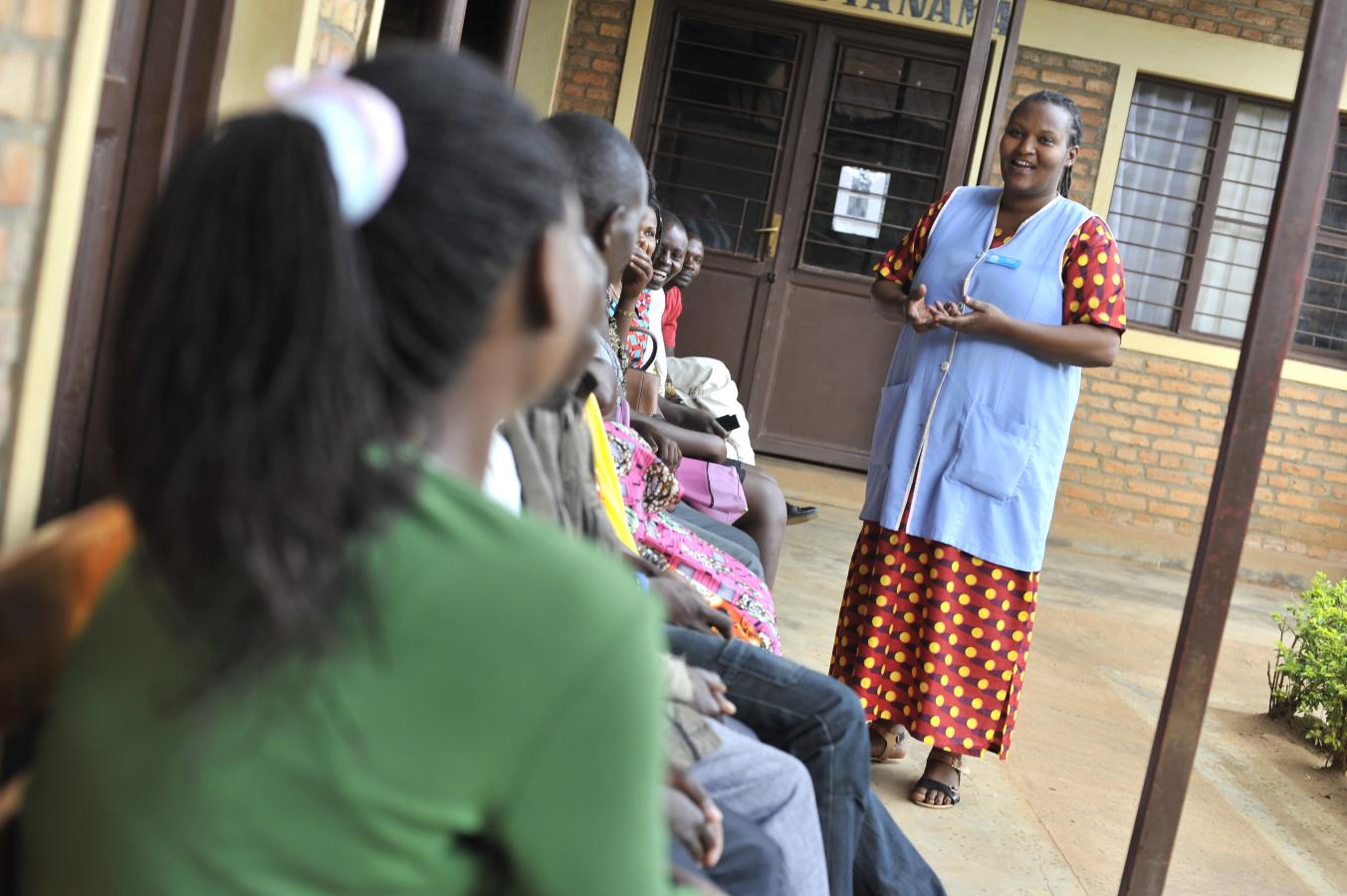 A health worker speaks to clients waiting for services at a clinic in Rwanda.