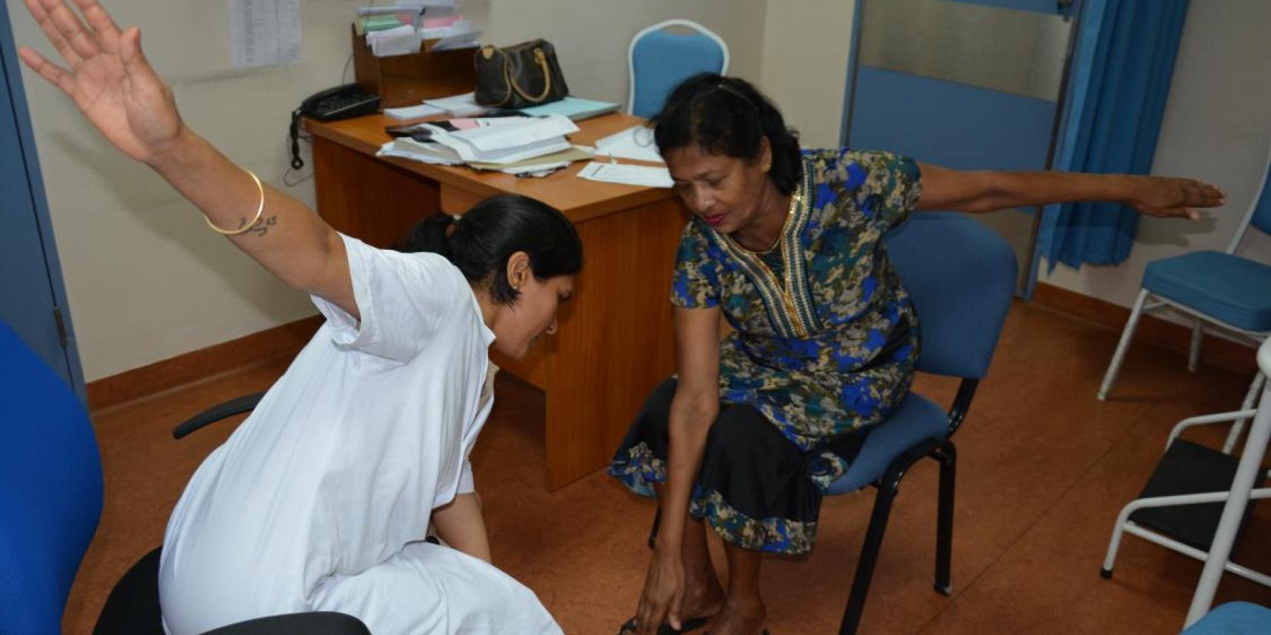 © Photoshare: A Diabetic Specialist Nurse in Port Louis, Mauritius, teaches a patient simple limb exercises.