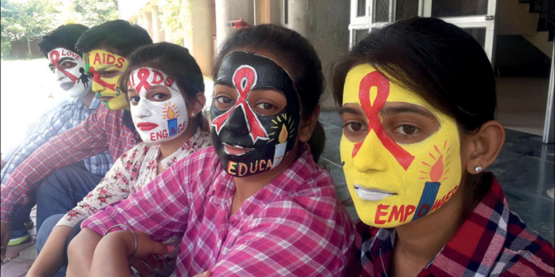 Students recognise International AIDS Candlelight Memorial Day with painted faces at the Centre for Social Work, Panjab University, Chandigarh, India.