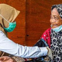health worker in indonesia taking blood pressure