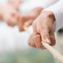 Close up of hands pulling a rope